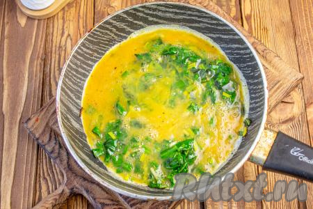 Влейте яичную смесь к обжаренной черемше, перемешайте, доведите на среднем огне до готовности яиц (в течение минут 3), не накрывая крышкой и периодически помешивая.