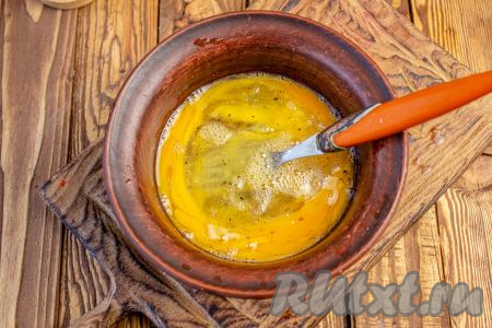 В небольшую ёмкость разбейте яйца, перемешайте их вилкой, посолите и поперчите.