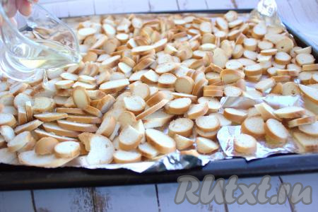 Противень застелить фольгой (или пергаментом), выложить баранки, нарезанные на кружочки, стараясь, чтобы они лежали в один слой. Полить подсолнечным (или оливковым) маслом.