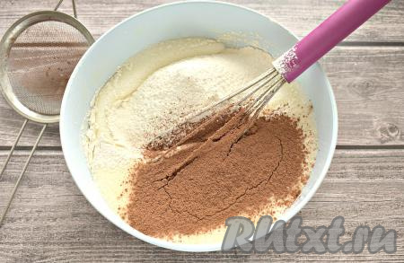 Далее в получившуюся смесь просеиваем 100 грамм муки и какао-порошок, перемешиваем венчиком до однородности.