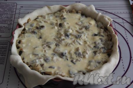 Соединить отдельно сметану и яйца, перемешать венчиком (или вилкой) до однородности, получившуюся заливку равномерно распределить поверх курино-грибной начинки.