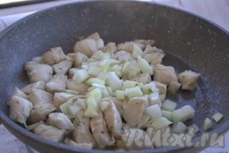 Затем в сковороду с обжаренной курицей выложить нарезанный лук, перемешать и, уменьшив огонь до среднего, обжаривать минуты 3, не забывая периодически помешивать.