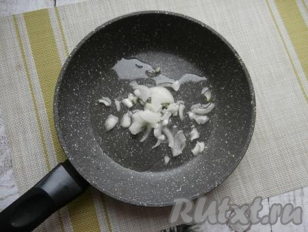 Очищенную луковицу нарезать на тонкие кусочки, выложить в сковороду, влить растительное масло.