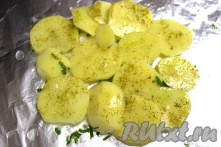 Взять кусок фольги. Я смазала фольгу маслом, в котором мариновались стейки. В центр фольги выложить две картошины, нарезанные на кружочки.