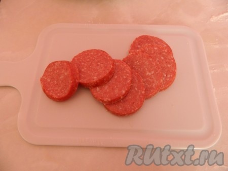 Пока пекутся коржи, есть чем заняться, режем колбасу на кружочки.  