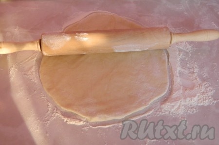 Через час, когда тесто поднялось, раскатываем его на присыпанной мукой поверхности. У меня получилось 2 небольших коржа.
