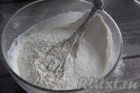 В миску с получившейся смесью всыпать разрыхлитель и большую часть просеянной муки, снова перемешать венчиком.