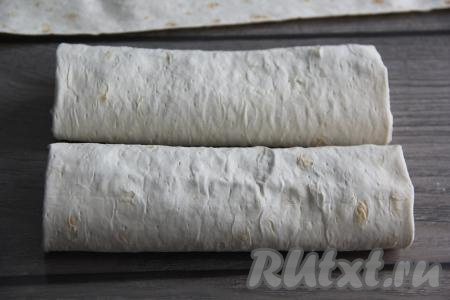 Завернуть начинку в лаваш, подворачивая вначале края лаваша на начинку с узких сторон, а затем свернуть в рулет, начиная с широкой стороны, формируя плоский штрудель. Аналогично сформировать второй штрудель из лаваша.