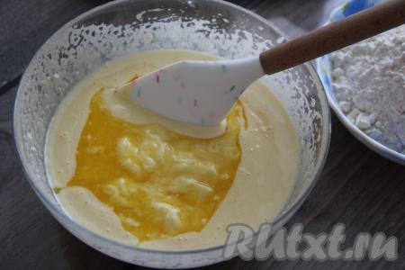 Сливочное масло растопить (можно это сделать в микроволновке). В творожную смесь влить негорячее растопленное масло и перемешать тесто лопаткой.
