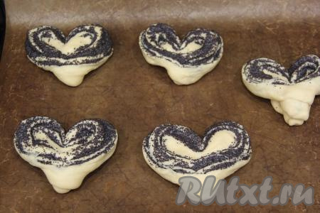 Развернуть плюшку, она по форме будет напоминать сердечко. Таким образом сформировать все плюшки с маком и выложить их на расстоянии друг от друга на противень, застеленный тефлоновым ковриком (или пергаментной бумагой). Оставить на 25-30 минут для расстойки.