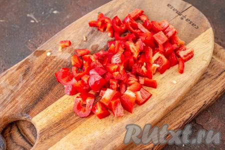 Болгарский сладкий перец очистите от семян, нарежьте на небольшим кубики. Когда картошка сварится до полуготовности, выложите в кастрюлю нарезанный перец.