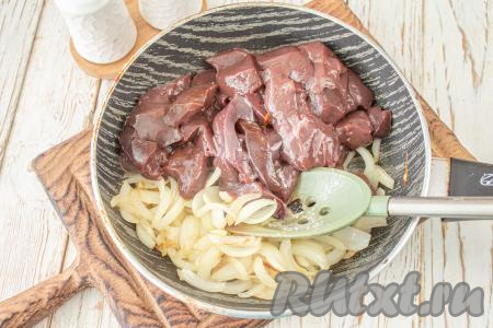 В сковороде нагрейте растительное масло, выложите лук и обжарьте его на среднем огне до золотистости (около 4-5 минут), иногда перемешивая. Затем добавьте печёнку, перемешайте.