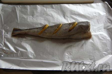 Переложить одну рыбку на лист фольги и завернуть в фольгу, плотно скрепляя края фольги со всех сторон. Аналогично завернуть в фольгу вторую навагу.