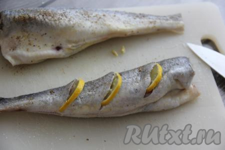 Лимон нарезать на кружочки. Сделать на каждой рыбке по три надреза и вставить в каждый надрез по кружочку лимона.