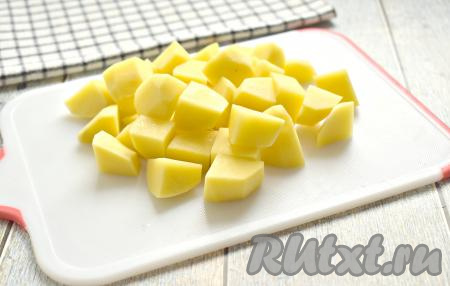 В кастрюлю наливаем 2 литра холодной воды, солим её и доводим до кипения. Очищенные картошины нарезаем на средние кубики, выкладываем в кастрюлю с закипевшей водой и после закипания варим минут 5.