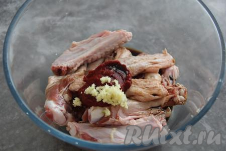 Выложить утиные крылья в миску, добавить соевый соус, томатную пасту и пропущенный через пресс чеснок.