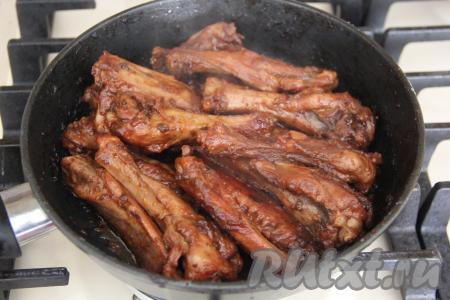Жарить крылышки на среднем огне со всех сторон до золотистого цвета (примерно, минут 15). Затем влить 50-60 мл воды. Накрыть сковороду крышкой и томить на медленном огне минут 25. За это время вода испарится, а утиные крылья покроются красивой и блестящей глазурью. Я за всё время томления два раза перевернула крылышки.