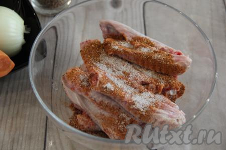 К крылышкам добавить соль и специи, перемешать.