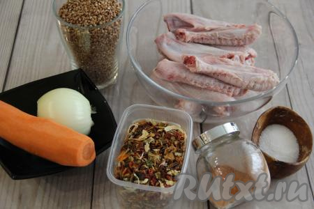 Подготовить продукты для приготовления утиных крылышек с гречкой в мультиварке. Утиные крылья промыть и разрезать по фалангам на 2 части. Лук и морковь почистить.