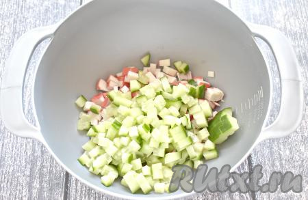 Моем свежий огурец, обрезаем с двух сторон, а затем нарезаем на небольшие кубики и добавляем его в миску с крабовыми палочками. Желательно, чтобы для крабового салата и палочки, и яйца, и огурцы были нарезаны на кусочки одинакового размера.