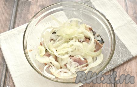 Очищаем репчатый лук. Нарезаем его тонкими полукольцами, добавляем к селёдке.