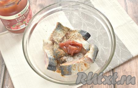 Добавляем к селёдке томатную пасту (можно также использовать кетчуп или томатный соус), аккуратно перемешиваем так, чтобы все кусочки рыбки покрылись пастой и специями.