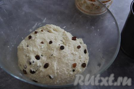 Добавить в тесто изюм и хорошо вмешать его руками в тесто. Чтобы изюм был более нежным в выпечке, его можно предварительно запарить в кипятке (то есть залить кипятком на 5 минут, а затем воду слить и обсушить изюм на полотенце).