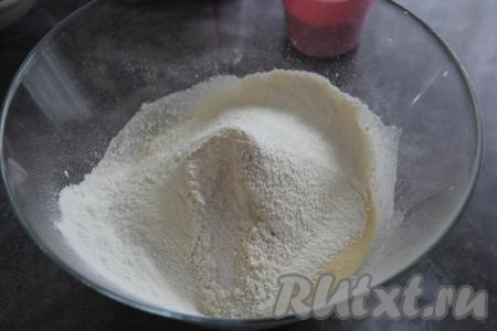 Частями в получившуюся массу всыпать просеянную муку, замешивая творожное тесто для кулича сначала ложкой, а затем - руками.