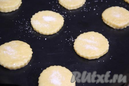 Раскатать тесто скалкой на присыпанной мукой поверхности в пласт толщиной 0,5 сантиметра. С помощью вырубки (или стакана) вырезать печенье любой формы и переложить заготовки на противень, застеленный тефлоновым ковриком (или пергаментной бумагой). Верх печенюшек присыпать сахаром (у меня на посыпку всех печенюшек ушла, примерно, 1 столовая ложка сахара).&nbsp;
