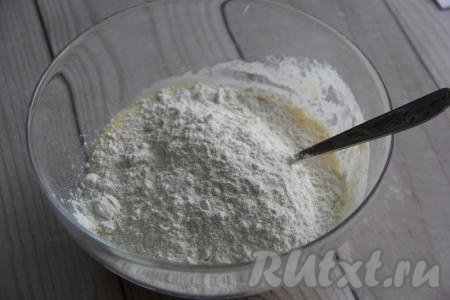 Начать всыпать частями просеянную муку, замешивая тесто сначала вилкой, а затем вымесить руками.