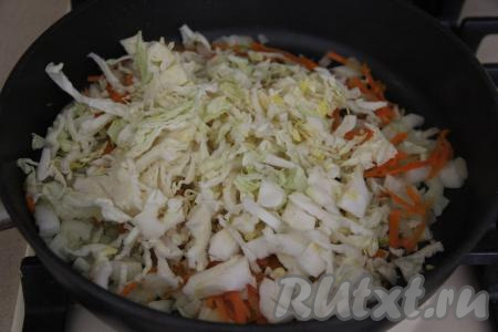 К обжаренным овощам выложить достаточно тонко нарезанную капусту, перемешать и тушить на небольшом огне под крышкой, примерно, 20 минут, иногда помешивая.