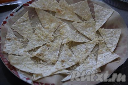 Сверху кусочки лаваша присыпать сыром, натёртым на мелкой тёрке. Поставить тарелку в микроволновку.&nbsp;