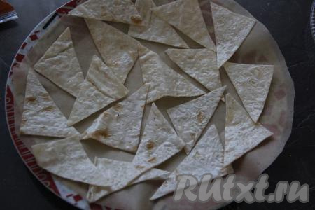 Круглую плоскую тарелку застелить пергаментом и выложить кусочки лаваша в один слой.&nbsp;