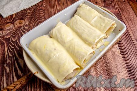 Смажьте поверхность лаваша ранее отложенным яйцом со сметаной. Куриное филе в лаваше запекайте 25-30 минут в духовке, заранее разогретой до 190 градусов.