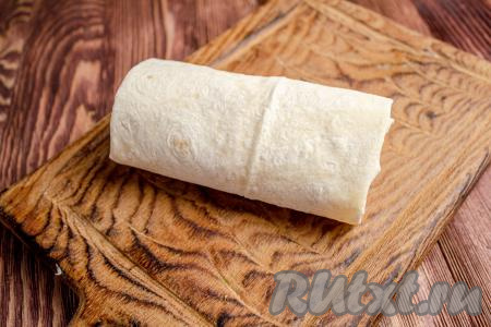 Сверните лаваш в рулет, начиная с узкой стороны.