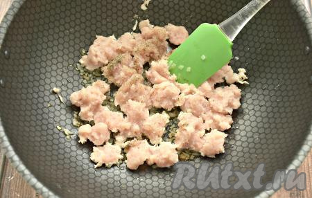 Добавляем к луку куриный фарш, по вкусу солим и перчим, немного уменьшаем огонь.