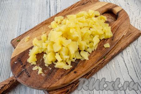 Картофель промойте, выложите в кастрюлю, залейте водой и отварите в кожуре до готовности (обычно на отваривание требуется минут 25-30). Картошка должна быть не разваренной и хорошо держать форму. Отваренную картошку остудите, очистите и нарежьте на небольшие кубики.
