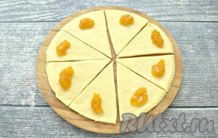 Ближе к основанию каждой треугольной заготовки, как на фото, кладём 0,5 чайной ложки повидла.