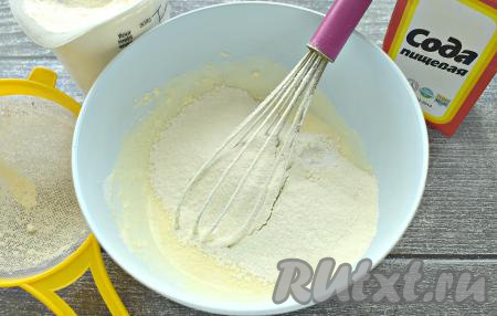 В получившуюся смесь всыпаем соду и часть просеянной муки, перемешиваем венчиком.