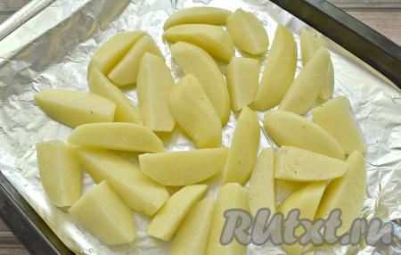 Противень застилаем куском фольги с «запасом». Выкладываем картошку в один слой.