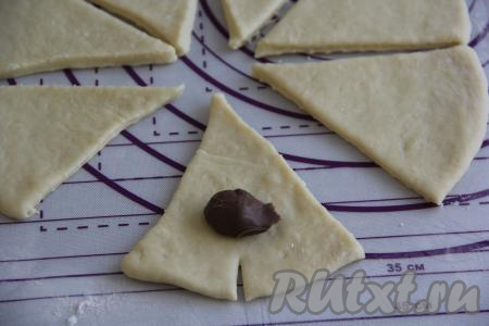 Можно сформировать рогалики без начинки, слегка присыпав сегменты сахаром. А можно сделать с начинкой, выложив ближе к основанию каждого сегмента 1/2 чайной ложки шоколадной пасты (или джема, или очень густого варенья).