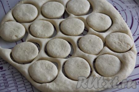 Подошедшее тесто обмять и раскатать на присыпанной мукой поверхности в пласт толщиной, ориентировочно, 1,5 сантиметра. Вырезать пончики любого диаметра. Накрыть полотенцем и оставить на минут 20-30.