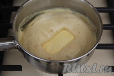 Снять сотейник с медовой массой с огня и выложить в него сливочное масло комнатной температуры, перемешать до однородности. Слегка остудить медовую массу.