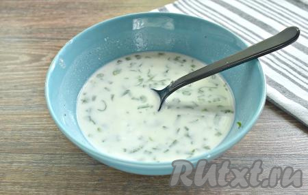 Пока жарится рыбка, приготовим заливку из сметаны. Для этого в миску выкладываем сметану, вливаем к ней тёплую кипячёную воду, немного солим, перчим, добавляем нарезанную зелень, перемешиваем.