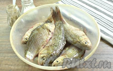 Каждого карасика натираем солью и перцем снаружи и внутри. По желанию, можно добавить приправу для рыбы, но я обхожусь без неё. Карасей минут на 5 оставляем мариноваться в специях.