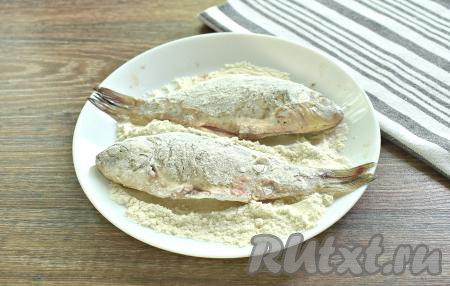 Карасей со всех сторон обваливаем в пшеничной муке, которую для удобства насыпаем на тарелку.