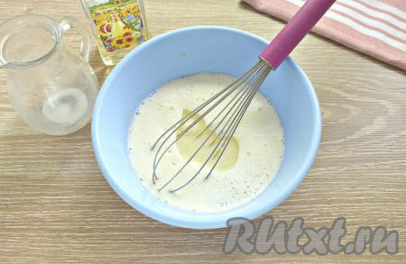 В эту смесь вливаем тёплое молоко (примерная температура молока 38-39 градусов), добавляем 3,5 столовых ложки растительного масла, перемешиваем молочную смесь венчиком до однородности.