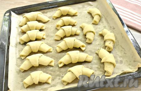 Складываем рогалики на противень, застеленный пергаментом, "хвостиками" вниз. Накрываем полотенцем и оставляем в тёпле на 20-30 минут для расстойки.