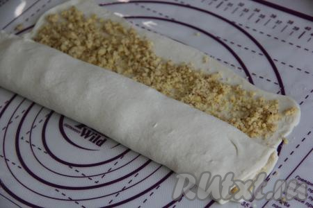 Завернуть тесто с начинкой в плоский рулет, начиная с широкой стороны пласта слоёного теста.&nbsp;