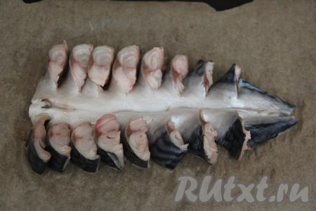 Противень застелить пергаментом. Выложить заготовку из рыбы шкуркой вверх. Развернуть кусочки филе вертикально.